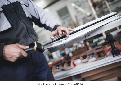Manual worker assembling PVC doors and windows. Manufacturing jobs. Selective focus. Factory for aluminum and PVC windows and doors production.