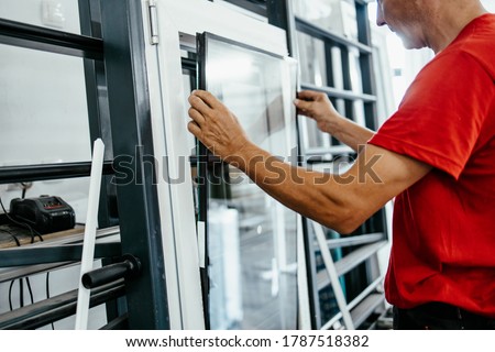 Manual worker assembling PVC doors and windows. Factory for aluminum and PVC windows and doors production. Selective focus. 