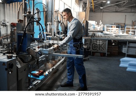 Manual worker assembling windows at factory