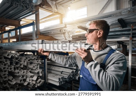 Manual worker assembling windows at factory