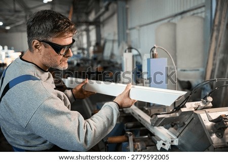 Manual worker assembling windows at factory