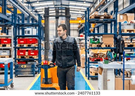 Manual worker carrying a handcart in a warehouse of a logistic center