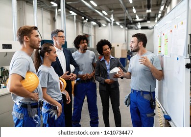 Manual worker communicating with company leaders and his coworkers during business presentation in a factory. 