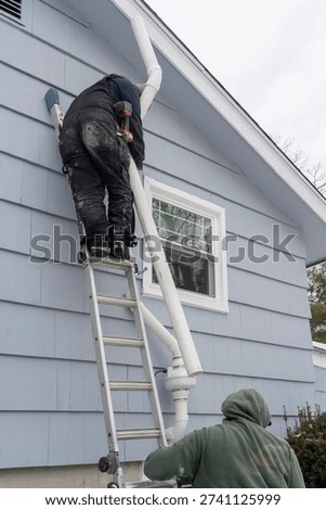 manual worker installing radon mitigation system outside the house