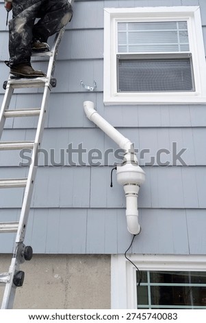 manual worker installing radon mitigation system outside the house