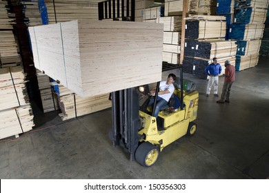 Manual worker operating a forklift truck in lumber industry - Powered by Shutterstock