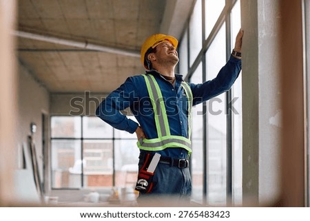 Manual worker suffering from lower back pain while working at construction site. 