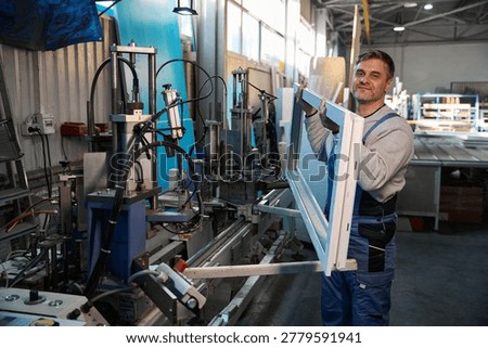 Manual worker working in factory assembling PVC windows