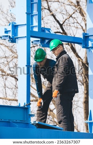 Manual workers working at shipyard construction site. Industry