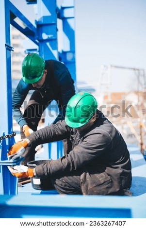 Manual workers working at shipyard construction site. Industry