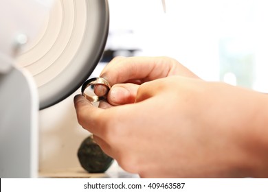 Manually creating jewelry. Jeweler polishes jewelry for jewelry polisher.  - Powered by Shutterstock