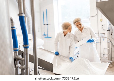 Manufacture, Industry, Food Production And People Concept - Women Technologists With Paper And Powdered Milk At Ice Cream Factory Shop