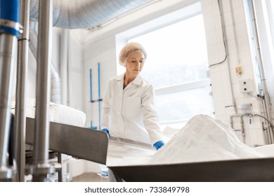 Manufacture, Industry, Food Production And People Concept - Woman Working At Ice Cream Factory Conveyor With Powdered Milk