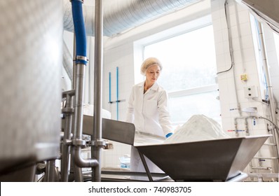 Manufacture, Industry, Food Production And People Concept - Woman Working At Ice Cream Factory Conveyor With Powdered Milk