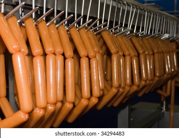 Manufacture of sausages. Sausages hang on the conveyor.