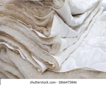 Manufacture of warm quilted blankets. Clothing industry. Filler for blankets. Sheep wool and synthetic winterizer in microfiber and cotton fabric