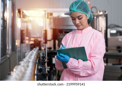 Manufacturer checking product bottles fruit juice on the conveyor belt in the beverage factory. Woman worker checks product bottles in beverage factory. Inspection quality control - Powered by Shutterstock