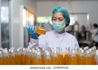 Manufacturer Worker Checking Product Bottles Fruit Juice On Shelf Pallet Parcel In The Beverage Factory. Manufacturer And Inspection Quality Control