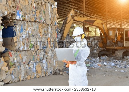 Manufacturers Engineer and tablet working at plastic bag manufacturers.Engineer and Recyclable material. An engineer looking at recycling waste To proceed to the next process. 
