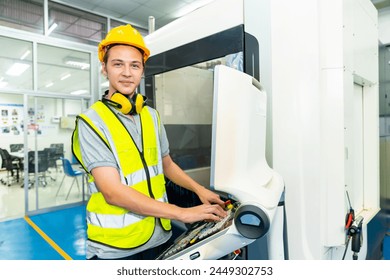Manufacturing industry factory manufacturing technology concept. Portrait of Caucasian man engineer worker in safety wear working and maintaining control CNC lathe machine system in factory plant room