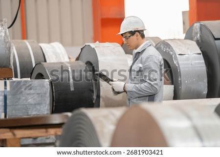Manufacturing process overview engineer inspects steel rolls in factory industrial environment focused viewpoint quality control