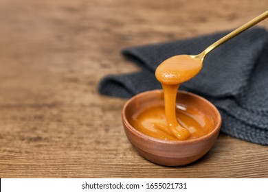 Manuka Honey Dipper Dipping In Raw Organic Liquid From Manuka Flowers In New Zealand .Bees Harvesting Exclusively From This Healthy Antibacterial Antifungal Property Flower.