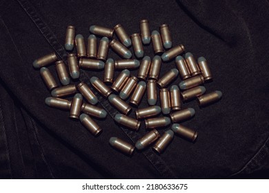 Many .45 ACP Cartridges On A Black Denim Background