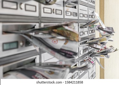 Many advertising leaflets are hanging from an overloaded letterbox. Spam concept. - Shutterstock ID 1584211858