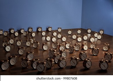 Many Alarm Clocks On A Wooden Floor. Art Installation.