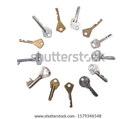 Many assorted old multi-colored metal antique keys of different shapes laid out in circle isolated on white background. Home security concept. Copy space for text.