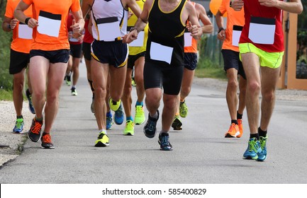 Many Athletes During The Road Race In The City On The Asphalt Road And White Bib Number