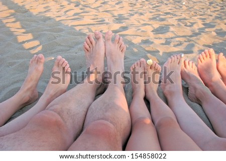 many barefoot of a family on the shore of the sea on the beach with children 4