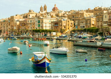 many beautiful boats in Valletta harbour with cityscape on the background, Malta