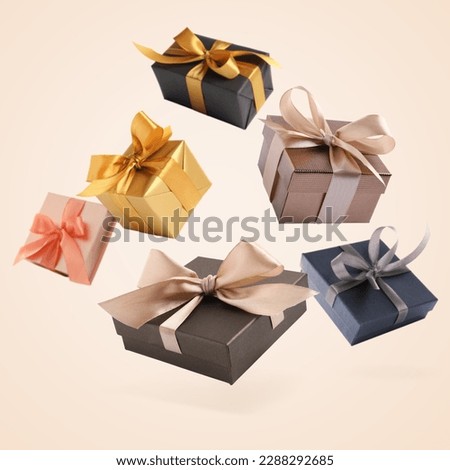 Many beautiful gift boxes falling on beige background