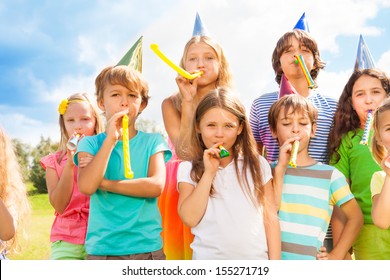Many Beautiful Kids Outside On A Birthday Party Blowing Noisemakers Horns And Twisted Whistles