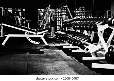 Many Black Dumbbells In Dark Weight Room, Horizontal Photo