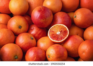Many blood oranges, whole and halved (full frame)