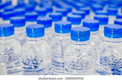 Many blue drinking water bottle caps and pure drinking water bottles in a drinking water production plant. - Powered by Shutterstock