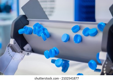 Many Blue Plastic Bottle Caps Falling From Conveyor Belt At Factory, Exhibition - Production Line. Manufacturing, Recycling, Industry, Technology Equipment Concept