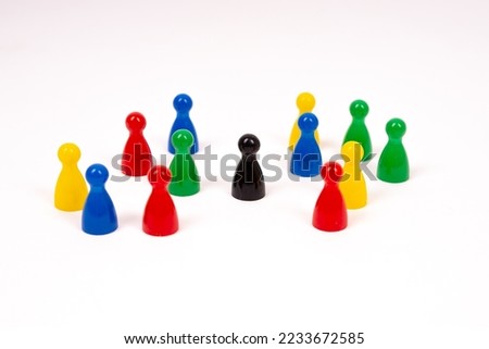 Many board game pawns on the table, selective focus on the black one. Be brave, be yourself. With a white background.
