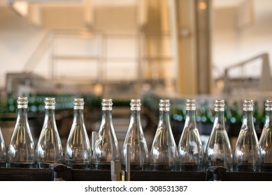 Many bottles on conveyor belt in factory