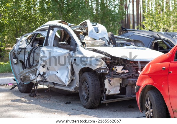 Many broken cars after a traffic accident in the\
parking lot of a restoration service station on the street. Car\
body damage workshop outdoors. Sale of insurance emergency vehicles\
at auction