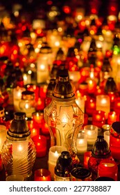 Many burning candles in the cemetery at night on the occasion memory of the deceased.