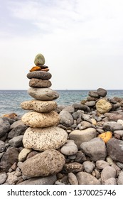 Many Cairns, With Sailing Ships In The Distance, Along The Coast Of Costa Adeje On Tenerife, Spain