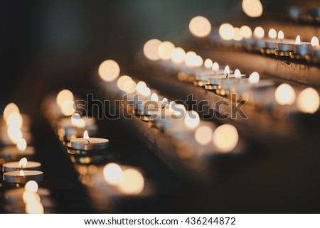 many candles burning church