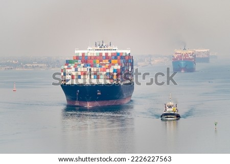 Many cargo ships navigate by Suez Canal, Egypt. Concept of distribution, shipping and delivery