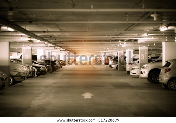 Many cars in parking garage interior,
industrial building. Vintage filter
effect.