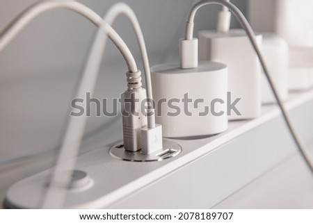 Many chargers plugged into maltiple electrical outlet on white background. Concept of electricity consumption.