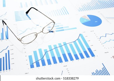 Many Charts And Glasses. Reviewing Data. Financial Reports And Glasses. Reflection Background.
