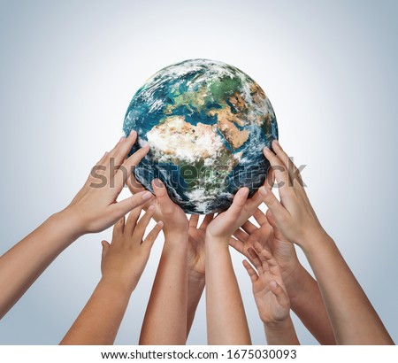 Many children hands holding planet earth isolated on blue background with copy space